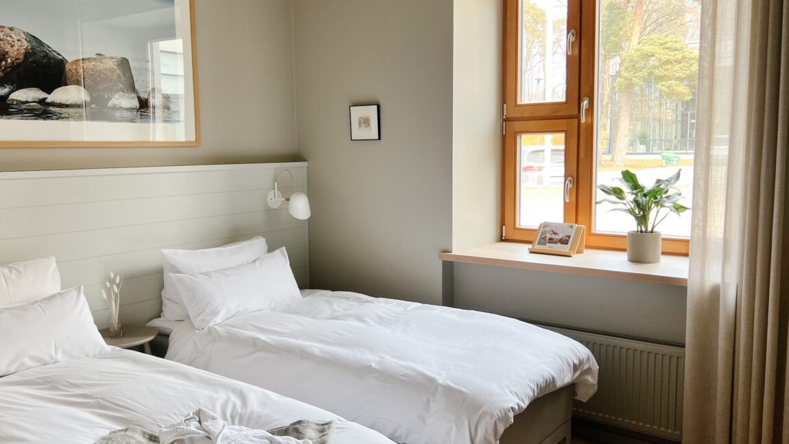 LaSpa beach house room with twin beds, wooden window, soft natural light, minimalist Nordic interior and calm atmosphere
