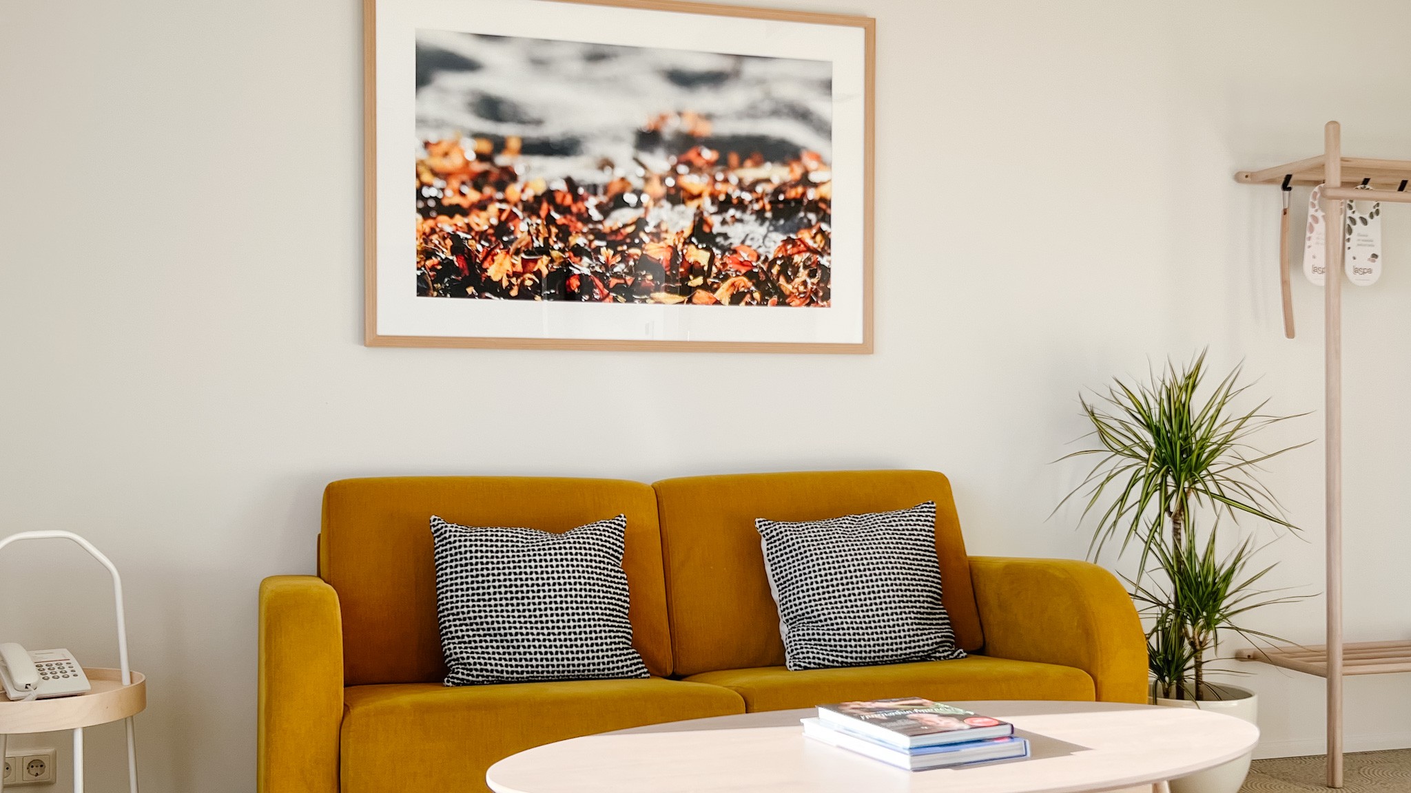 LaSpa suite living area with mustard sofa, minimalist Nordic interior, soft light, wooden details and calm atmosphere